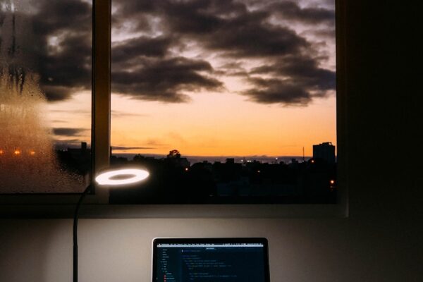 turned on laptop on desk near window
