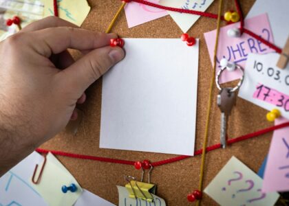 shallow focus photo of white paper sheet mounted on cork board