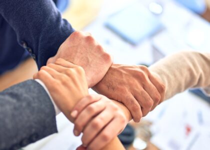 person in black long sleeve shirt holding persons hand